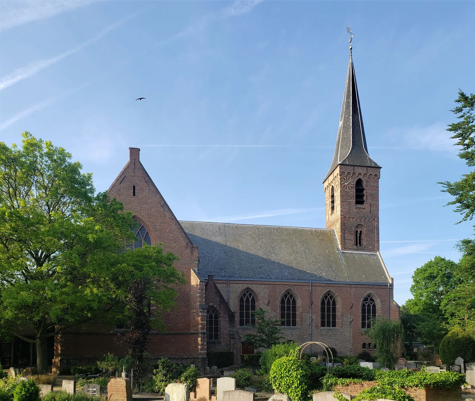 De Dorpskerk van Wassenaar met haar spitse toren, gezien vanaf het kerkhof